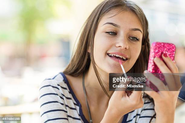 teen girl fixing her make up - teen girls stockfoto's en -beelden