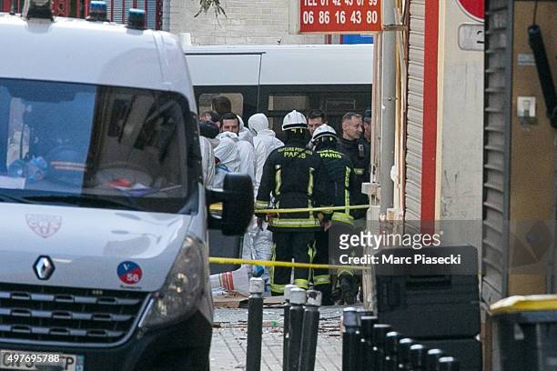 French Police Forensics officers and firefighters work on Rue des Corbillon in the northern Paris suburb of Saint-Denis following a raid on an...