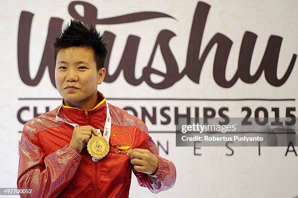 Luan Zhang of China celebrates with her gold medal on the podium during the Women's 52kg Sanda Competition medals ceremony of the 2015 World Wushu...