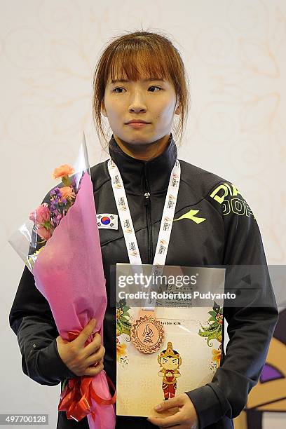 Hyebin Kim of Korea celebrates with her bronze medal on the podium during the Women's 52kg Sanda Competition medals ceremony of the 2015 World Wushu...