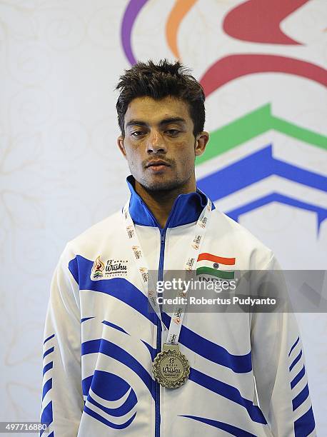 Uchit Sharma of India celebrates with his silver medal on the podium during the Men's 52kg Sanda Competition medals ceremony of the 2015 World Wushu...