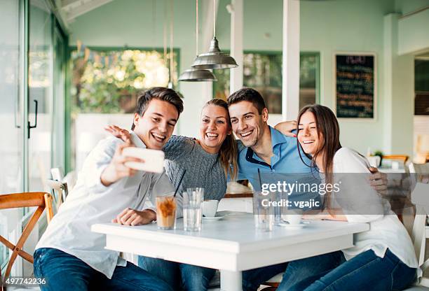 freunde, die selfie mit smartphone im restaurant. - vier personen stock-fotos und bilder