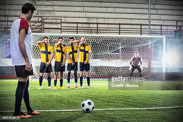 football match in stadium: free kick - verdediger voetballer stockfoto's en -beelden
