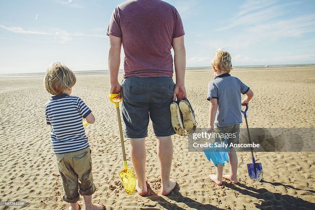 Father and sons on the beach together