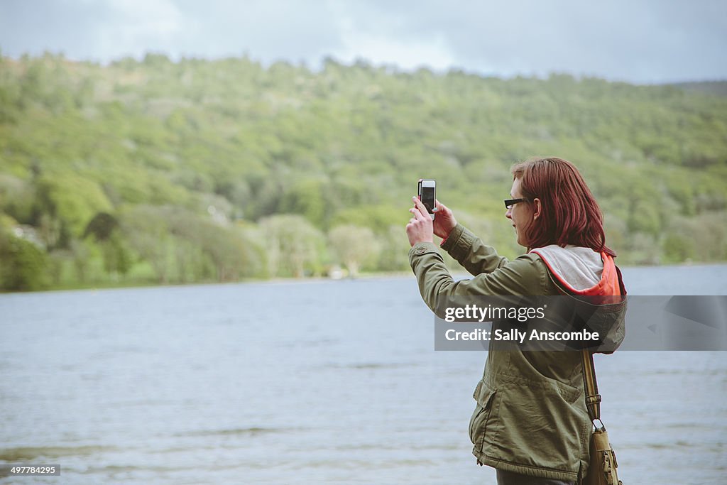 Young girl taking a photo with a phone