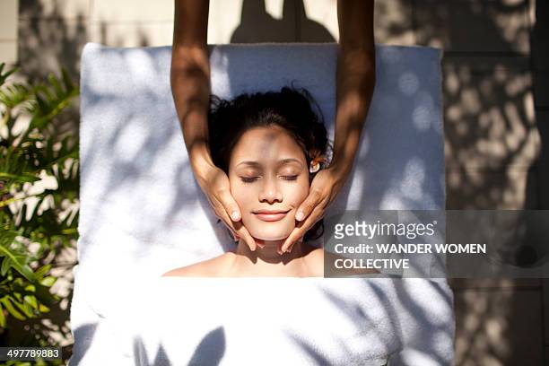 woman tropical massage facial beauty treatment - healing hands stockfoto's en -beelden