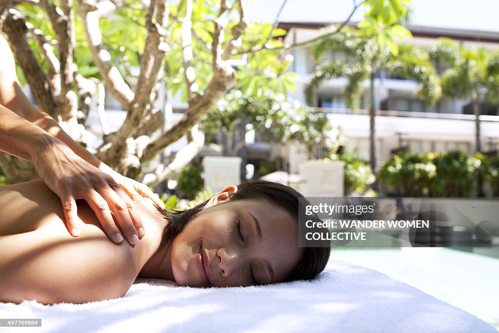 Woman having massage by a resort pool
