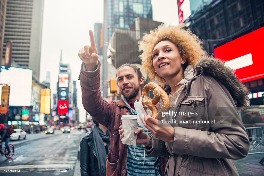 Raza mixta pareja de visita en Times Square, Nueva York, en el otoño.