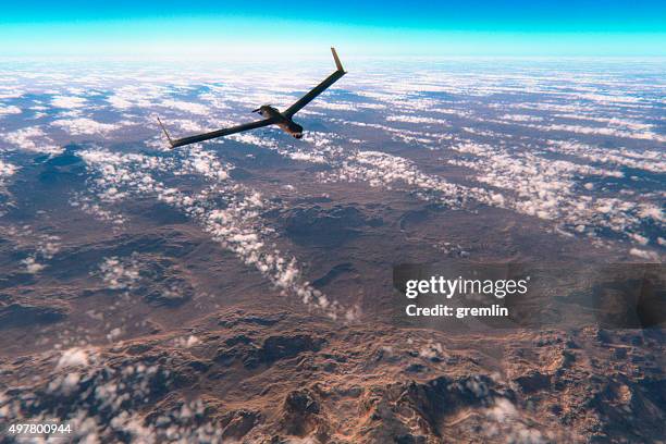 military surveillance drone flying over rocky deserts - high up stock pictures, royalty-free photos & images