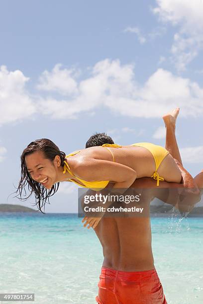 hombre con un chica sobre su hombro al mar - cultura caribeña fotografías e imágenes de stock