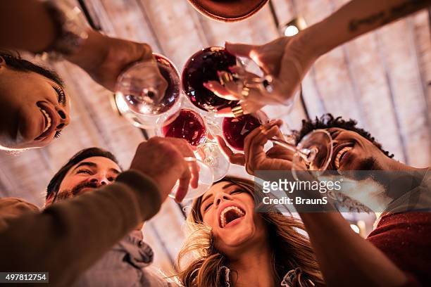 below view of group of friends toasting with wine. - sociale bijeenkomst stockfoto's en -beelden