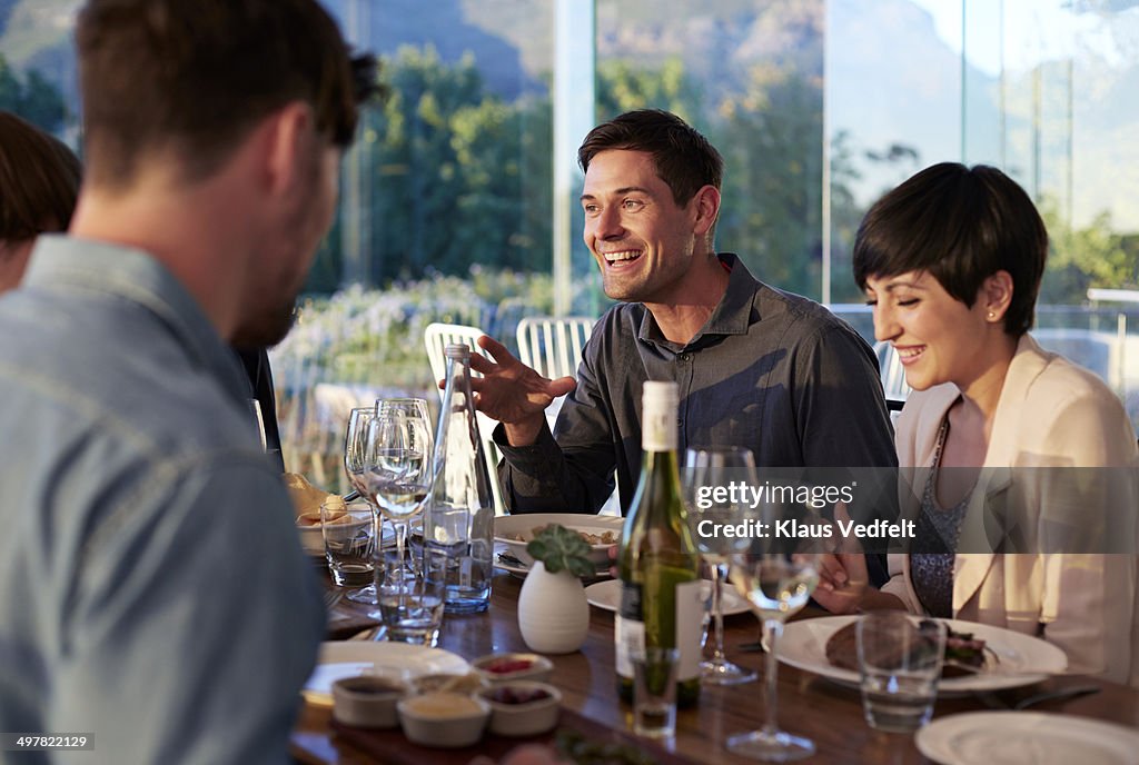 Man explaining at dinner with friends