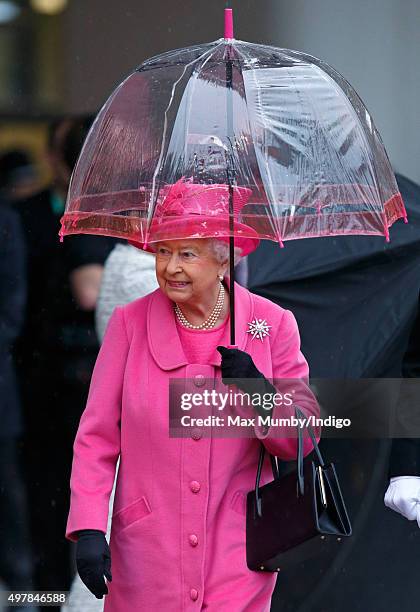 Queen Elizabeth II shelters under an umbrella as she visits the newly redeveloped Birmingham New Street Station on November 19, 2015 in Birmingham,...