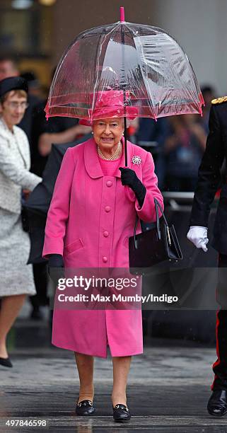 Queen Elizabeth II shelters under an umbrella as she visits the newly redeveloped Birmingham New Street Station on November 19, 2015 in Birmingham,...