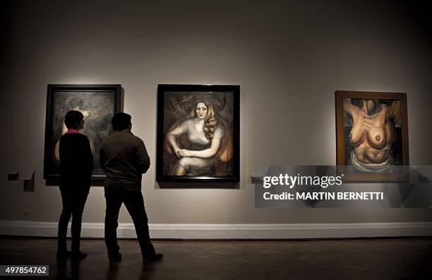 Workers of the Bellas Artes Museum observe works of Mexican painter David Alfaro Siqueiros before the oppening of the exhibition "Exposicion...