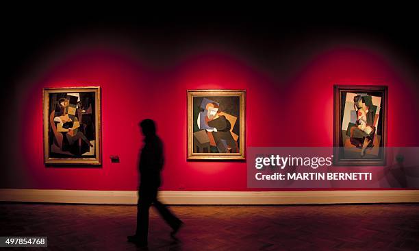 Worker of the Bellas Artes Museum passes by to works of Mexican painter David Alfaro Siqueiros before the oppening of the exhibition "Exposicion...