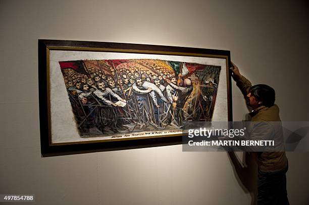 Worker of the Bellas Artes Museum places a work of Mexican painter David Alfaro Siqueiros before the oppening of the exhibition "Exposicion...