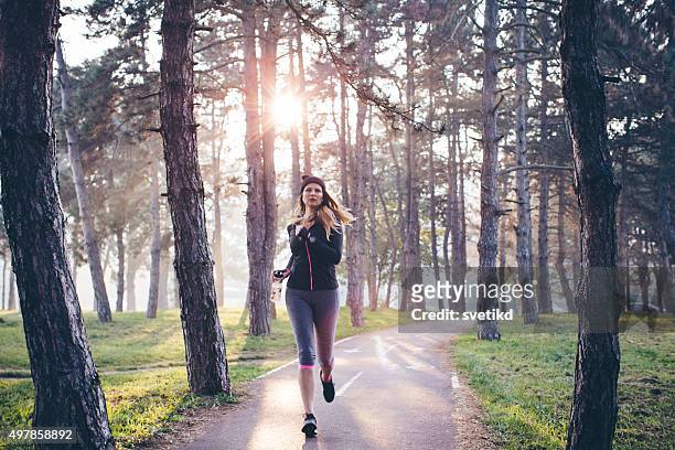 woman running in forest - woman winter sport stock pictures, royalty-free photos & images