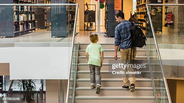 student and teacher in library - openbare bibliotheek stockfoto's en -beelden