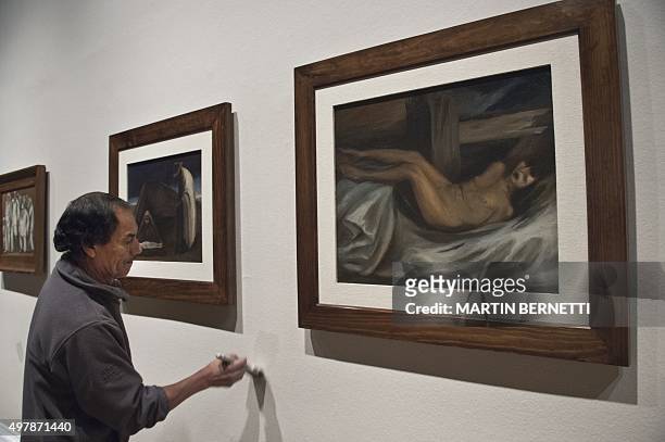 Worker of the Bellas Artes Museum makes final touchs next to works of Mexican painter Jose Clemente Orozco before the oppening of the exhibition...