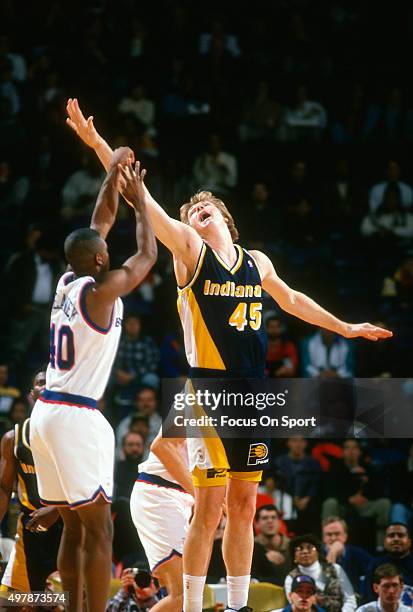 Rik Smits of the Indian Pacers attempts to block the shot of Calbert Cheaney of the Washington Bullets during an NBA basketball game circa 1995 at US...