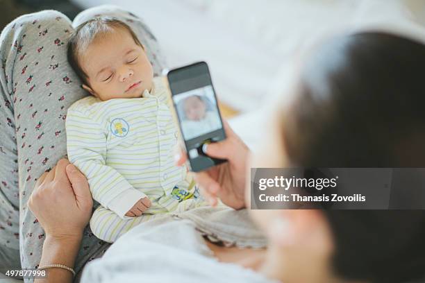 mother taking photo of her newborn son - funny baby photo - fotografias e filmes do acervo