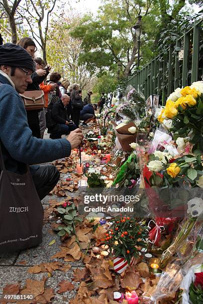 People lay flowers and light candles at a makeshift memorial for the victims of the Paris terror attacks outside the Bataclan concert hall in Paris,...