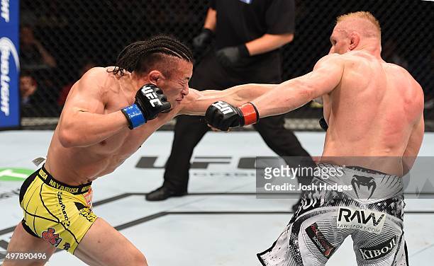 Tatsuya Kawajiri punches Dennis Siver in their featherweight bout during the UFC Fight Night event at the O2 World on June 20, 2015 in Berlin,...