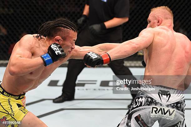 Tatsuya Kawajiri punches Dennis Siver in their featherweight bout during the UFC Fight Night event at the O2 World on June 20, 2015 in Berlin,...