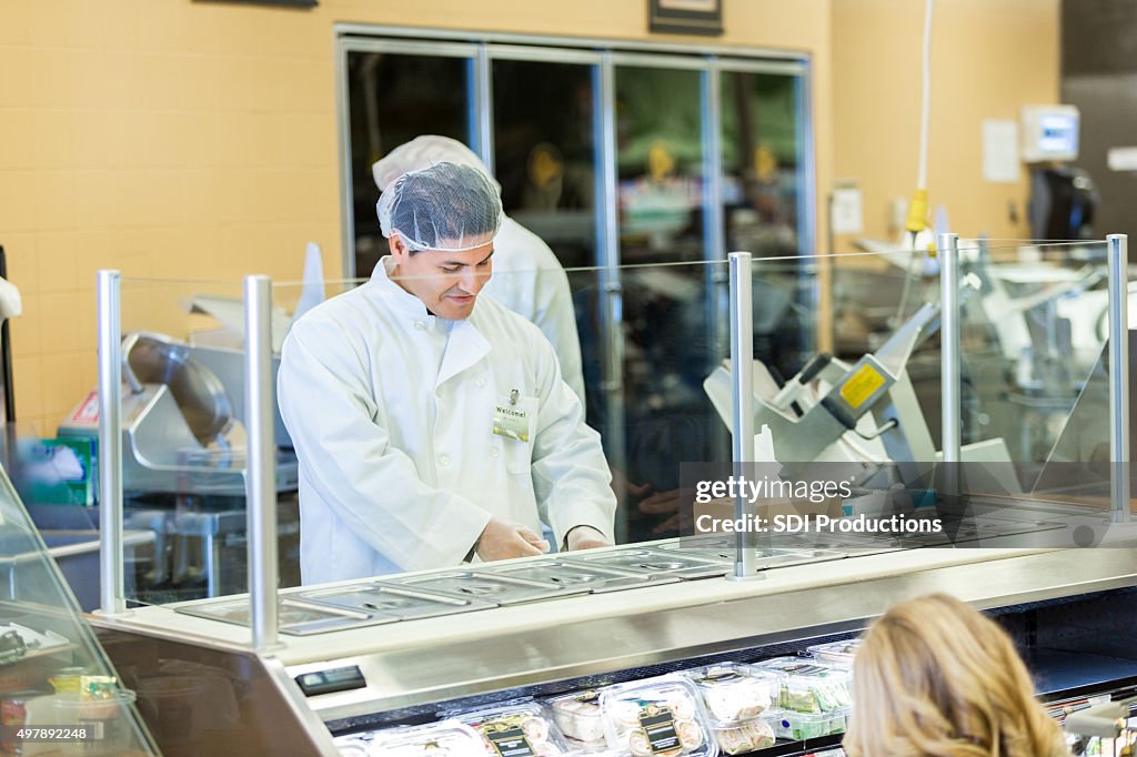 Boucher ou employé travaillant derrière le comptoir dans le magasin grcoery épicerie