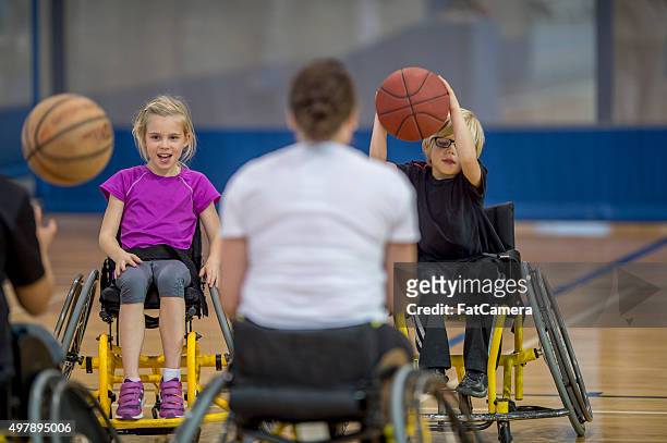 behindertengerechte menschen einen basketball dribbeln - kids playing sports stock-fotos und bilder