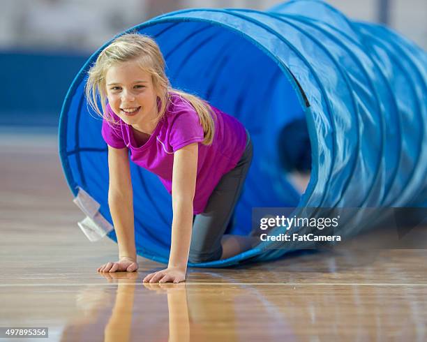 little girl crawling through a tunnel - assault courses stock pictures, royalty-free photos & images