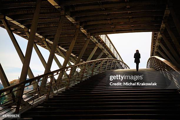 woman on passerelle solférino footbridge in paris, france. - voetgangersbrug stockfoto's en -beelden