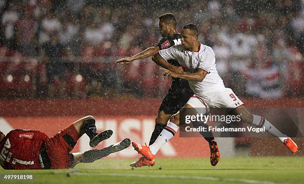 Luis Fabiano of Sao Paulo fights for the ball with Victor and Patric of Atletico during the match between Sao Paulo and Atletico MG for the Brazilian...