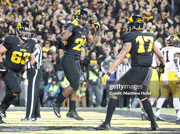 Runningback LeShun Daniels celebrates between offensive lineman Austin Blythe and wide receiver Jacob Hillyer of the Iowa Hawkeyes after a touchdown...