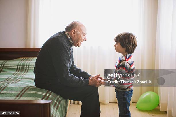 grandfather talking to his grandson - family serious stock pictures, royalty-free photos & images
