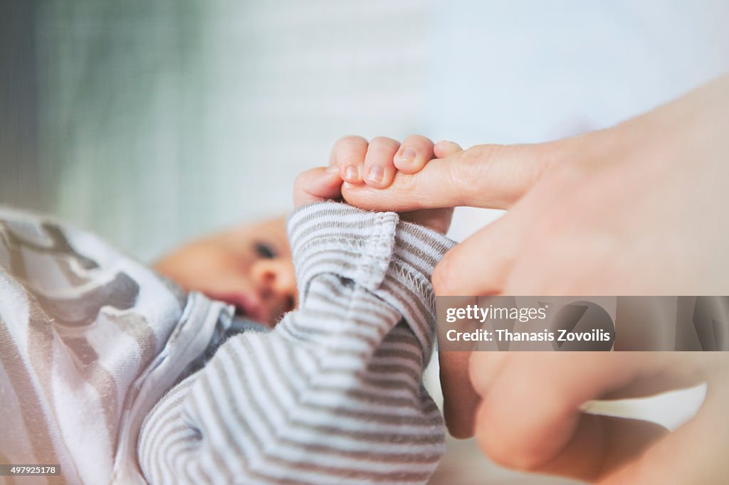 Mother holding her baby hand