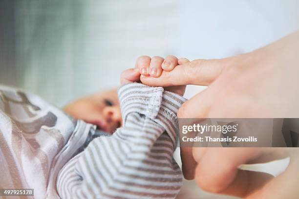 mother holding her baby hand - new mother stock pictures, royalty-free photos & images