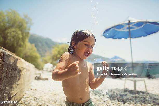 small boy playing with the shower on the beach - summer school stockfoto's en -beelden