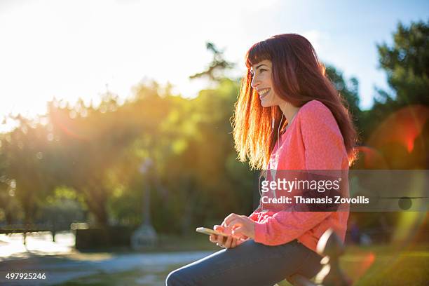 woman listening music outdoor - summer sounds stock-fotos und bilder