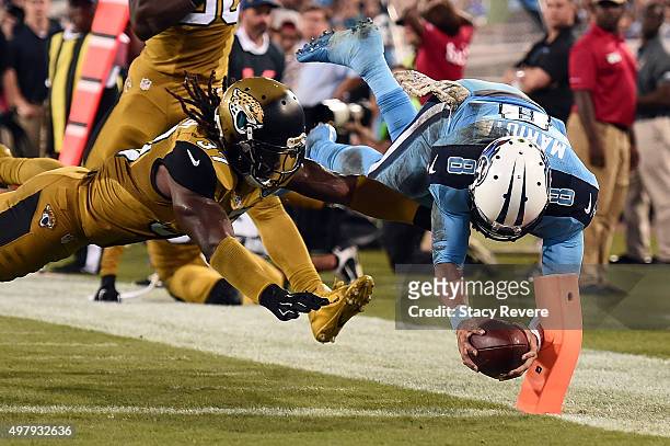 Marcus Mariota of the Tennessee Titans dives for touchdown in front of Johnathan Cyprien of the Jacksonville Jaguars during the third quarter of a...
