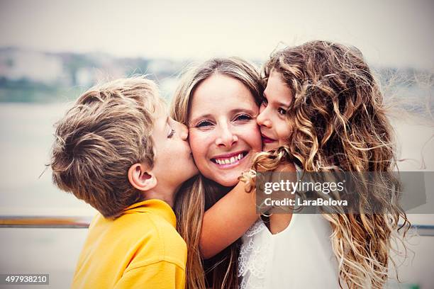 real happy mother with her kids - two kids kissing mom stock pictures, royalty-free photos & images
