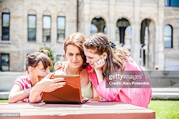 family, mother with two daughters, reading info at the laptop - scranton pennsylvania 個照片及圖片檔