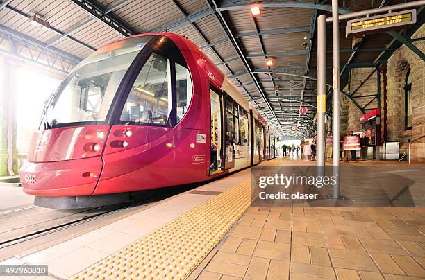 sydney tram, stationary at railway station. motion blurred commuters. - central station sydney stockfoto's en -beelden