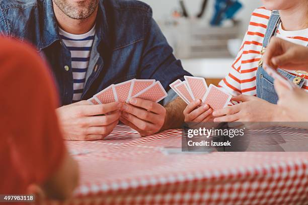 familie beim kartenspiel - hand of cards stock-fotos und bilder