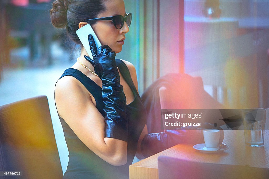 Beautiful, elegant woman talking on the mobile phone at cafe