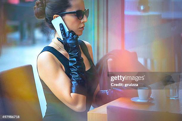 beautiful, elegant woman talking on the mobile phone at cafe - celebrity connected stock pictures, royalty-free photos & images