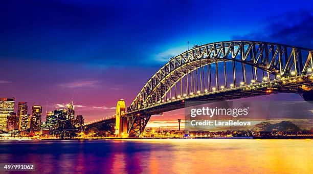 sydney harbour bridge bei sonnenuntergang - hafenbrücke von sydney stock-fotos und bilder