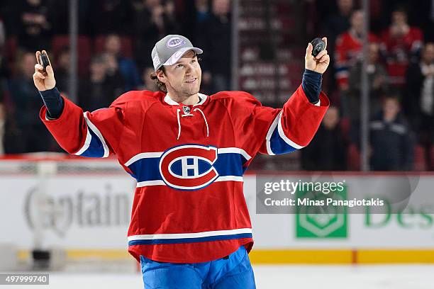 David Desharnais of the Montreal Canadiens holds up two pucks after being awarded the first star of the match during the NHL game against the...