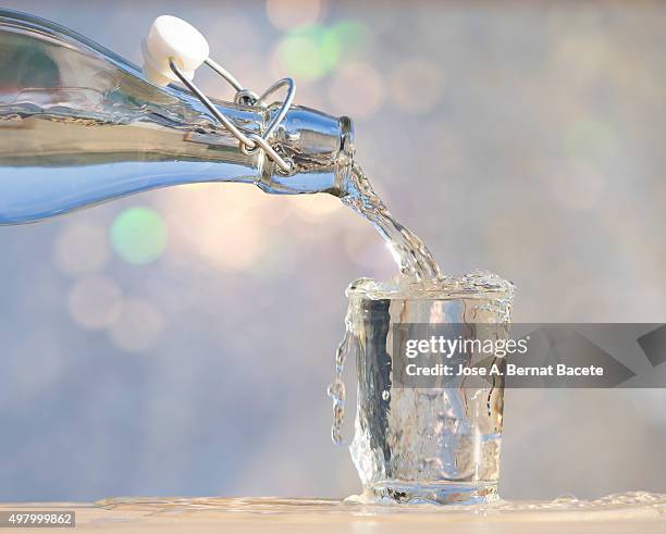 to fill a water glass with a glass bottle - agua purificada 個照片及圖片檔